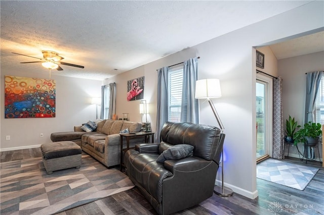 living room with dark hardwood / wood-style flooring, ceiling fan, lofted ceiling, and a textured ceiling