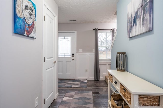 mudroom with dark hardwood / wood-style floors and a textured ceiling