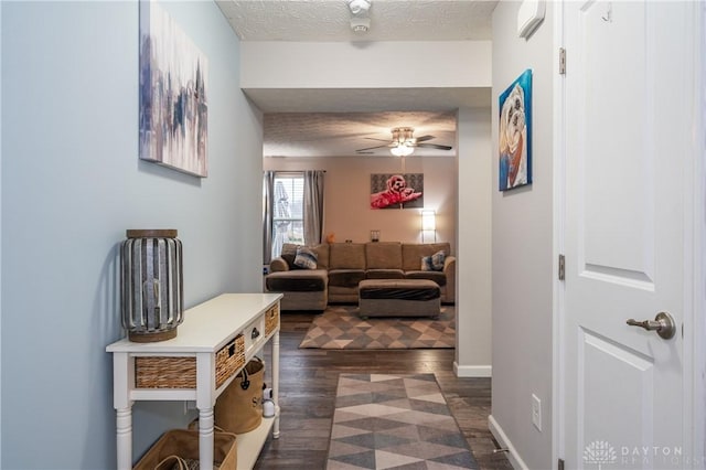 hall featuring dark wood-type flooring and a textured ceiling