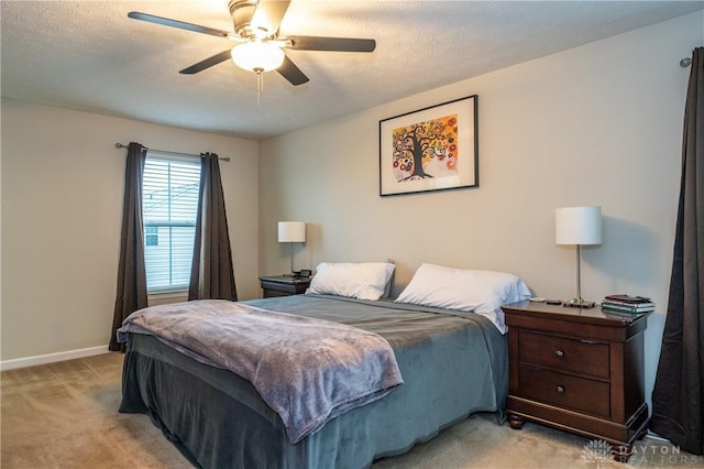 bedroom featuring ceiling fan, light carpet, and a textured ceiling