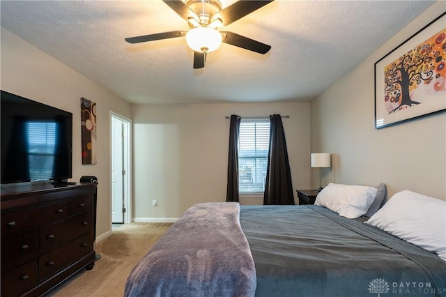 carpeted bedroom with ceiling fan and a textured ceiling