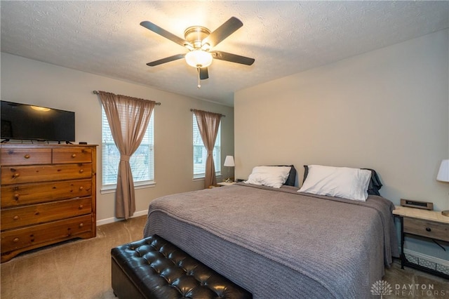 bedroom featuring ceiling fan, carpet, and a textured ceiling