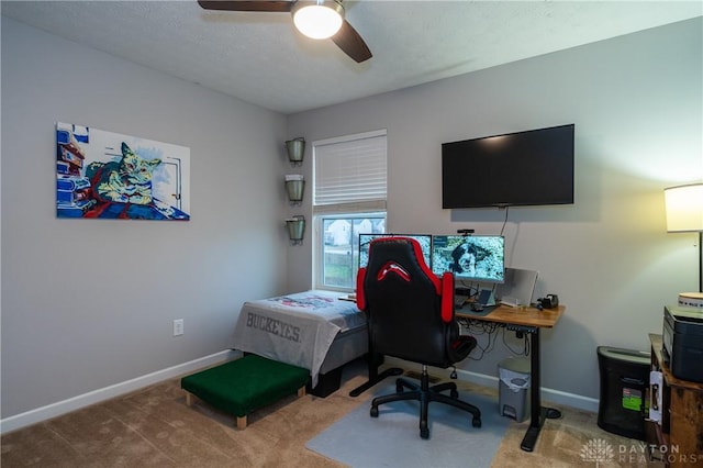 carpeted home office featuring ceiling fan