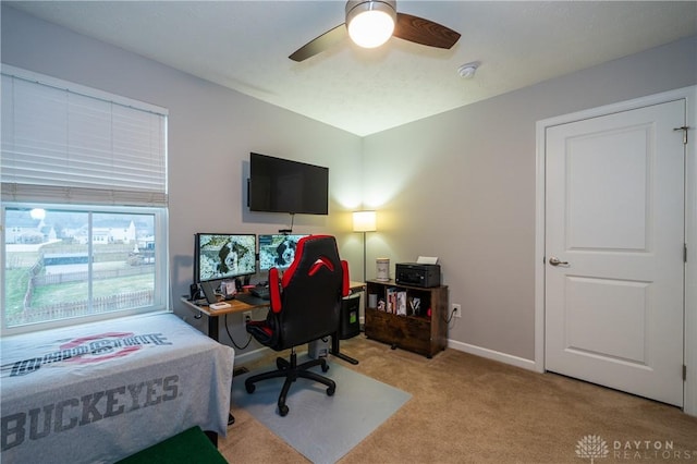 carpeted office space with ceiling fan