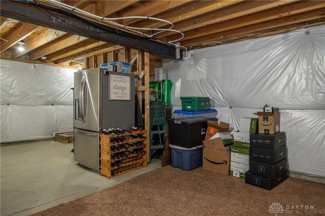 basement featuring stainless steel fridge with ice dispenser