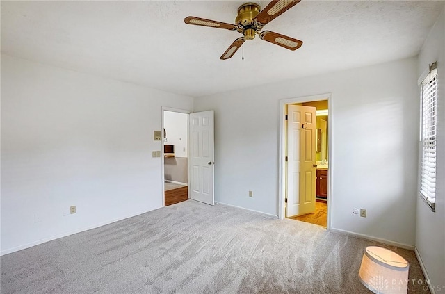 unfurnished bedroom with carpet floors, a ceiling fan, baseboards, and connected bathroom