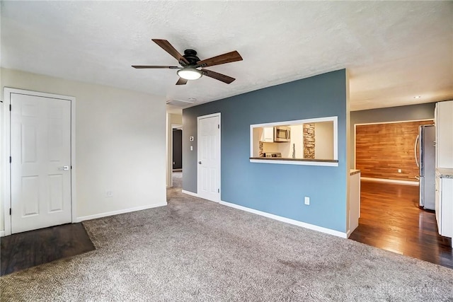 interior space with dark carpet, a textured ceiling, and ceiling fan