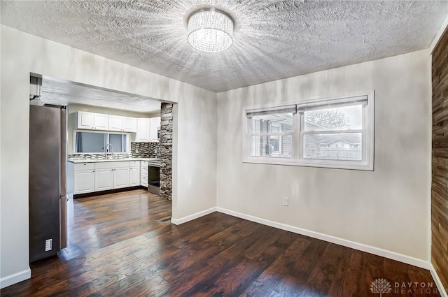 interior space featuring sink, white cabinetry, dark hardwood / wood-style floors, stainless steel fridge, and backsplash