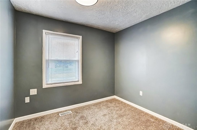 carpeted empty room with a textured ceiling