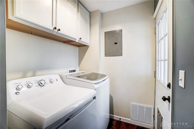 laundry room featuring cabinets, dark hardwood / wood-style flooring, electric panel, and washer and dryer