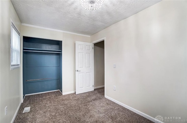 unfurnished bedroom with a closet, a textured ceiling, and carpet