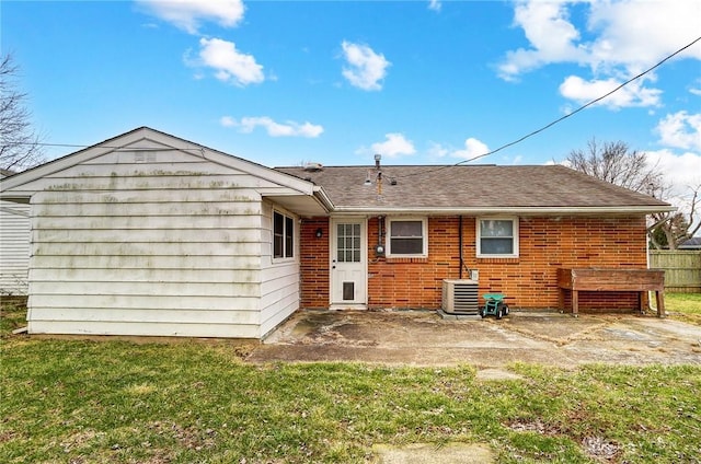 back of property with central AC unit and a lawn