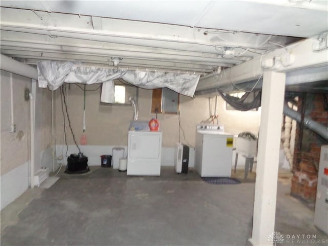 basement with electric panel and washing machine and dryer