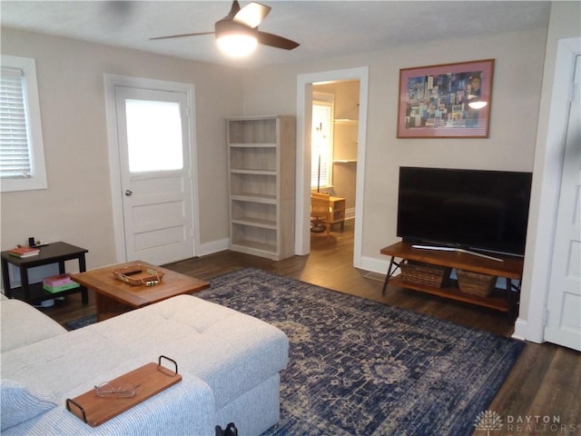 living room with ceiling fan and dark hardwood / wood-style flooring