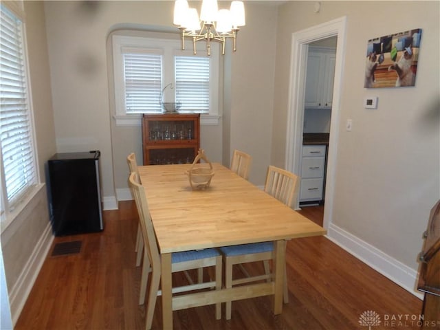 dining room featuring dark wood-type flooring and an inviting chandelier