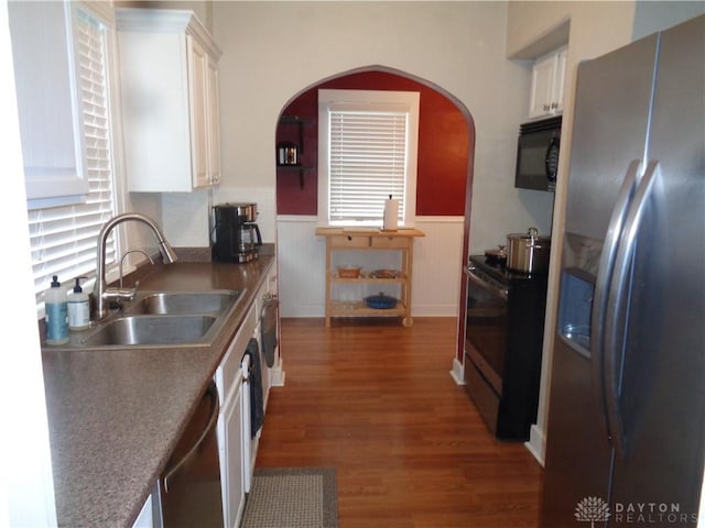 kitchen featuring appliances with stainless steel finishes, sink, white cabinets, and dark hardwood / wood-style flooring