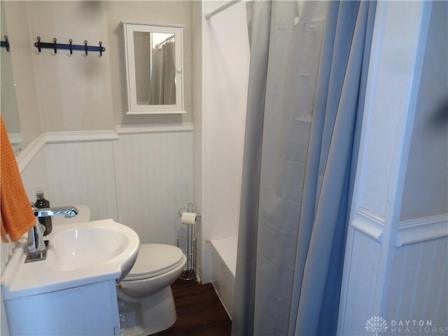 full bathroom with shower / tub combo with curtain, vanity, wood-type flooring, and toilet