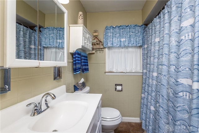 bathroom with tile patterned floors, toilet, a shower with curtain, tile walls, and vanity