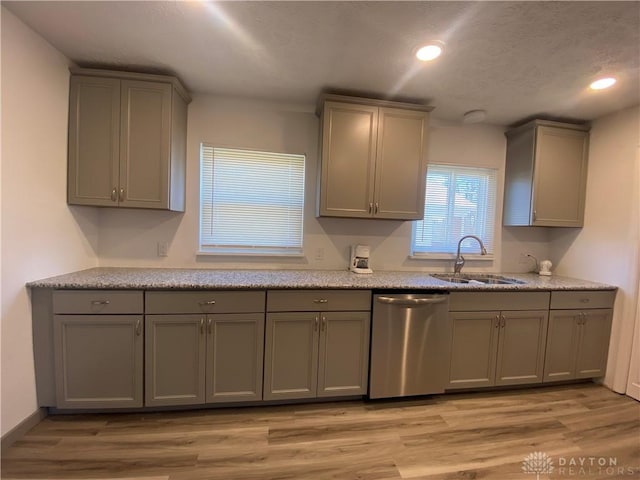 kitchen with gray cabinetry, sink, stainless steel dishwasher, and light wood-type flooring