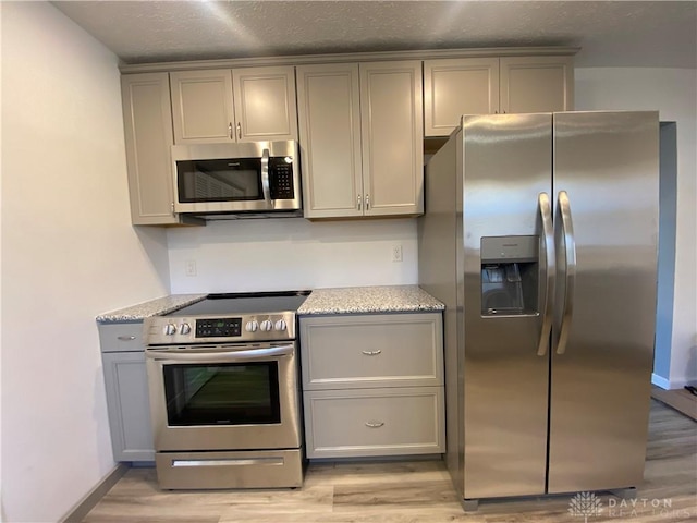 kitchen with appliances with stainless steel finishes and gray cabinets