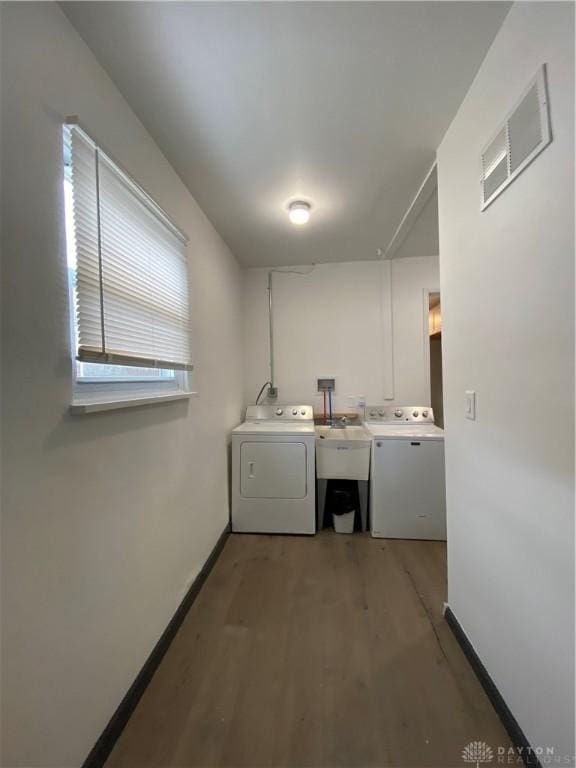 laundry room with separate washer and dryer, sink, and hardwood / wood-style floors