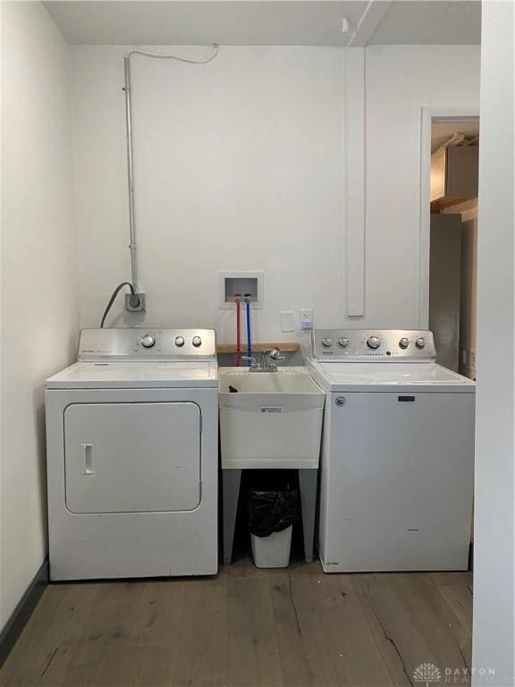 laundry room featuring hardwood / wood-style flooring, independent washer and dryer, and sink