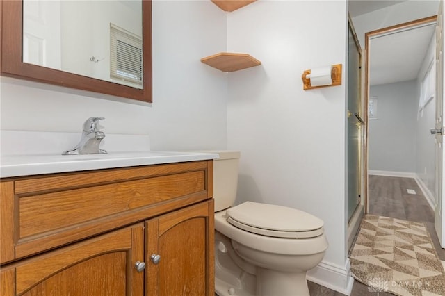 bathroom with vanity, a shower with shower door, and toilet