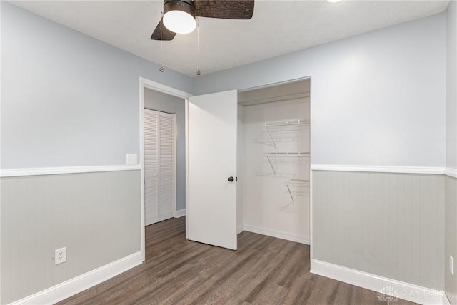 unfurnished bedroom with dark hardwood / wood-style flooring, a closet, and ceiling fan