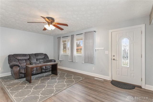 entrance foyer with hardwood / wood-style flooring, ceiling fan, and a textured ceiling