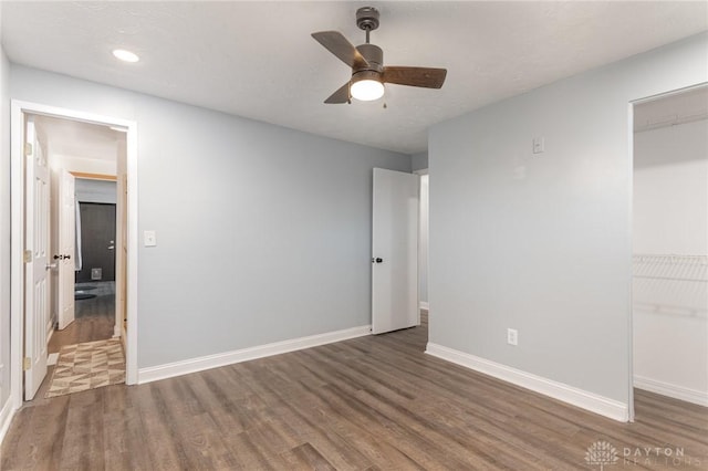 unfurnished bedroom featuring ceiling fan, dark hardwood / wood-style flooring, and a closet