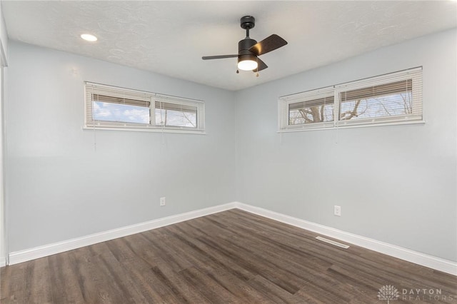 empty room featuring a textured ceiling, dark wood-type flooring, and ceiling fan