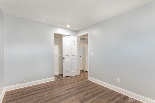 spare room with dark wood-type flooring and a textured ceiling