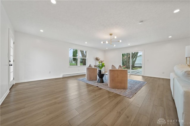 4260 Penny Pike, German Twp, OH 45502 - living area featuring a baseboard heating unit, healthy amount of natural light, recessed lighting, a chandelier, and wood finished floors
