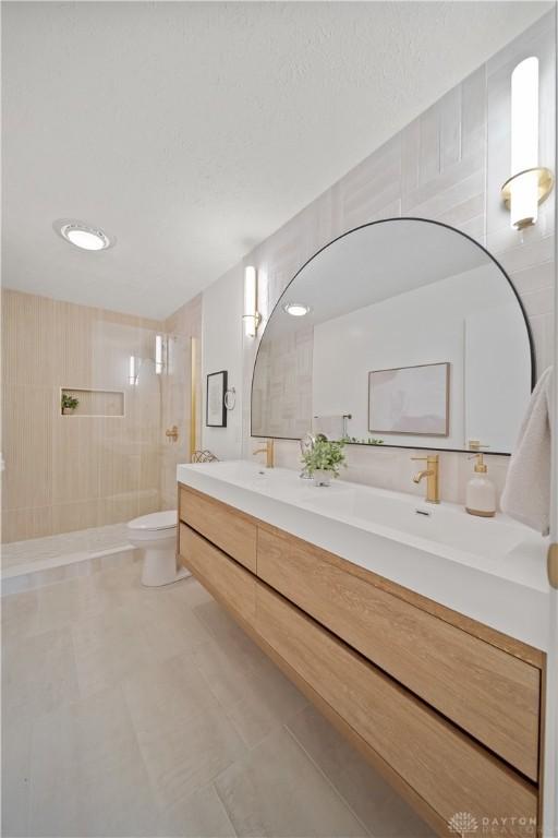 4260 Penny Pike, German Twp, OH 45502 - full bathroom featuring a walk in shower, double vanity, toilet, tile patterned floors, and a textured ceiling