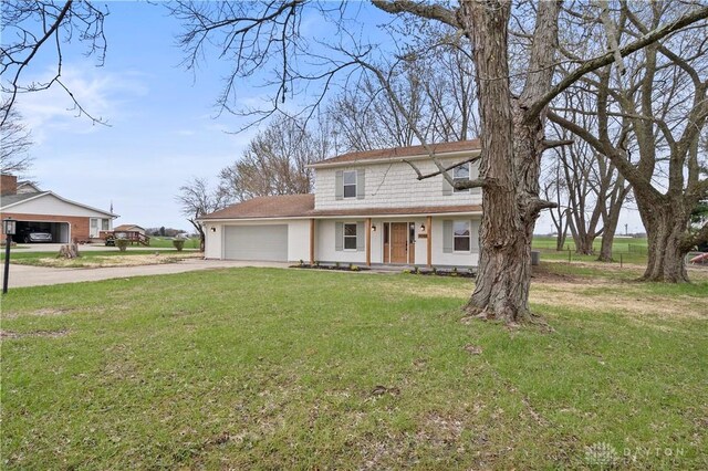4260 Penny Pike, German Twp, OH 45502 - view of front facade featuring concrete driveway, a garage, and a front yard