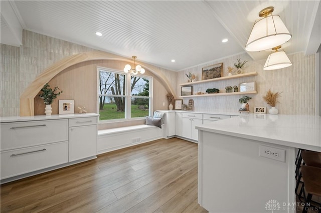 4260 Penny Pike, German Twp, OH 45502 - kitchen with open shelves, light wood-style flooring, a chandelier, light countertops, and white cabinetry