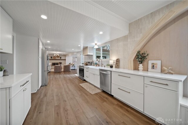 4260 Penny Pike, German Twp, OH 45502 - kitchen with stainless steel appliances, white cabinetry, light wood-style floors, light countertops, and open floor plan