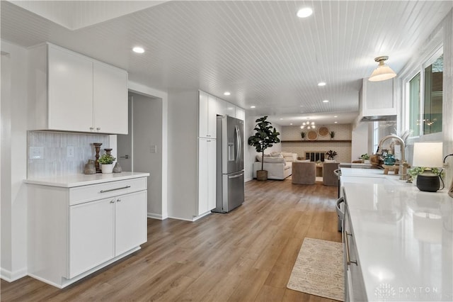 4260 Penny Pike, German Twp, OH 45502 - kitchen with stainless steel refrigerator with ice dispenser, recessed lighting, open floor plan, white cabinetry, and backsplash