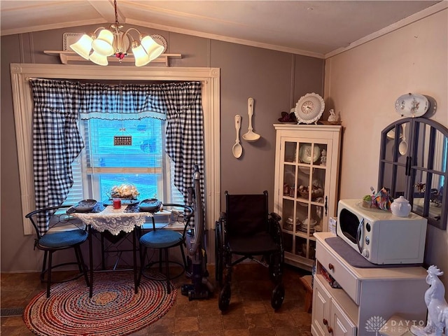 dining area featuring crown molding, vaulted ceiling, and a notable chandelier