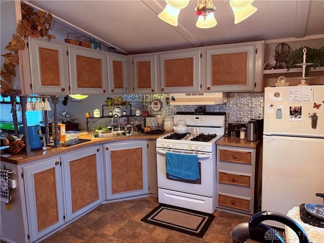 kitchen with lofted ceiling, sink, backsplash, and white appliances