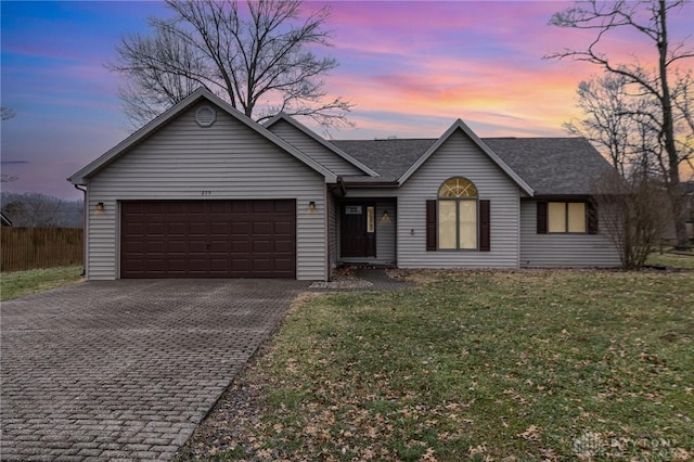 ranch-style house with a yard and a garage