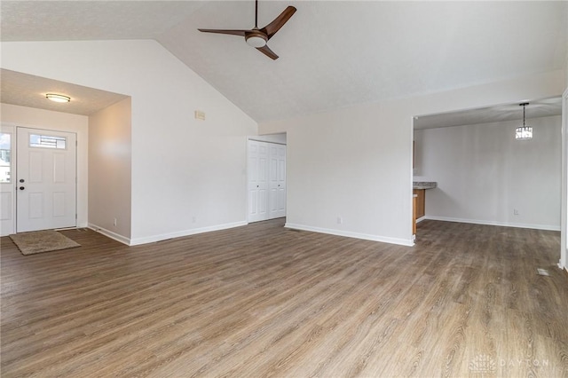 unfurnished living room featuring dark hardwood / wood-style flooring, high vaulted ceiling, and ceiling fan