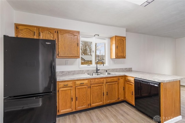 kitchen featuring light hardwood / wood-style flooring, sink, kitchen peninsula, and black appliances