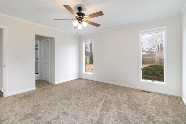 carpeted empty room featuring ornamental molding and ceiling fan