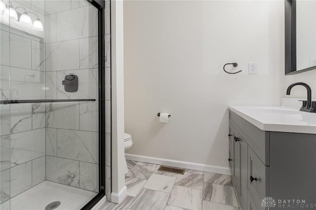 bathroom featuring vanity, toilet, and a shower with shower door