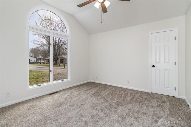 empty room with lofted ceiling, carpet floors, a wealth of natural light, and ceiling fan