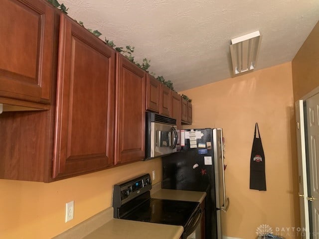 kitchen featuring black electric range oven and a textured ceiling