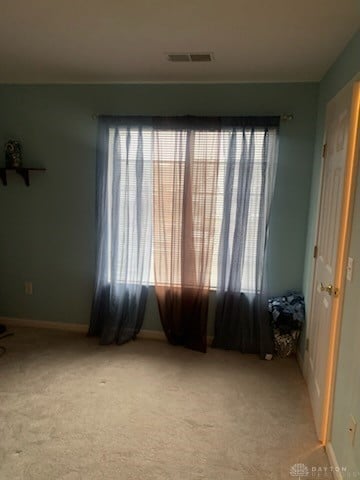 unfurnished room featuring light carpet