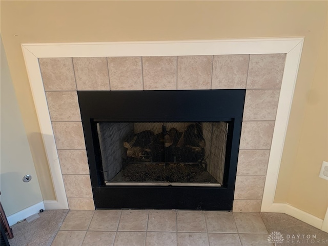 interior details featuring a tile fireplace