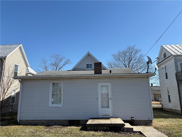 back of house featuring roof with shingles